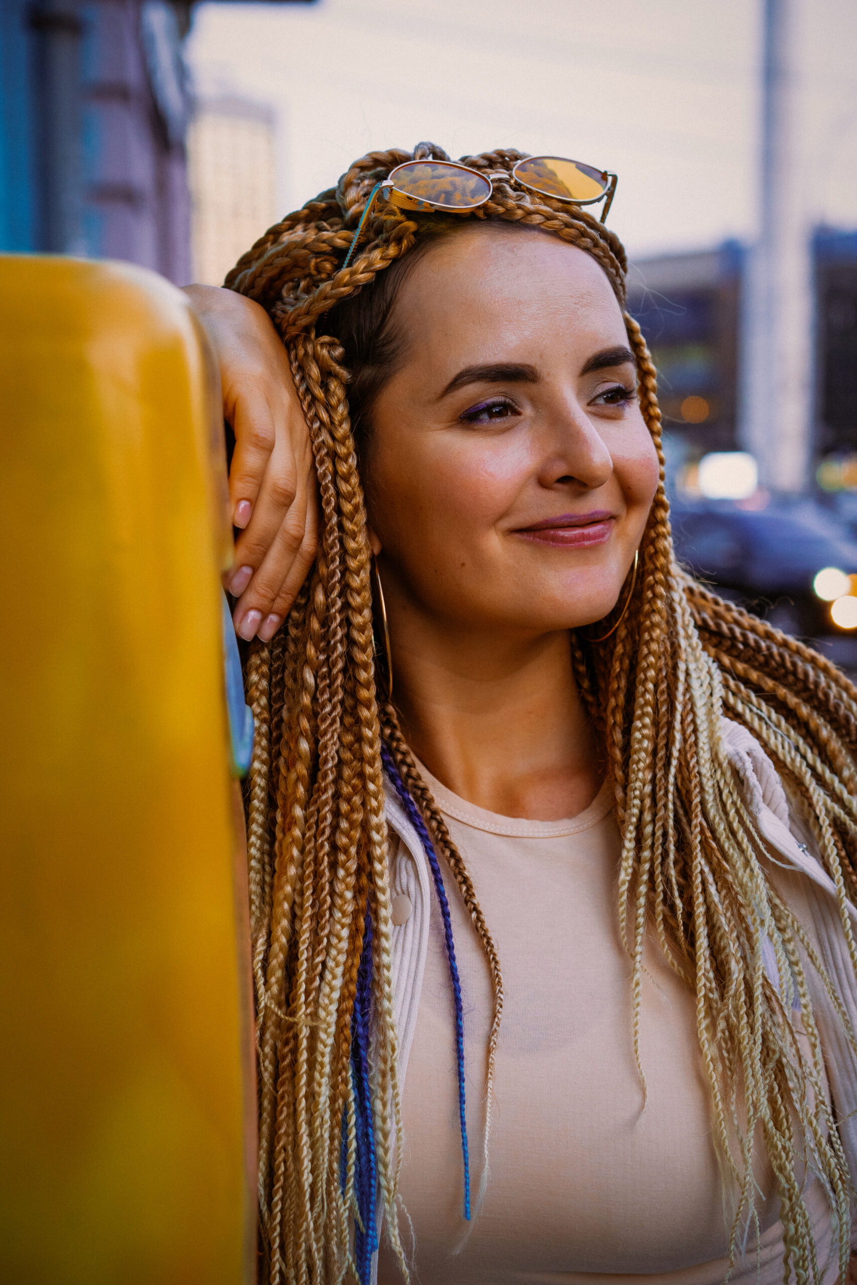 young woman with afro zizi braids and bright makeup in a big cit